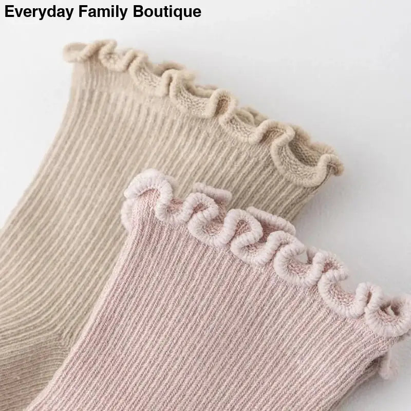 Ribbed socks with ruffled trim in beige and pink colors.