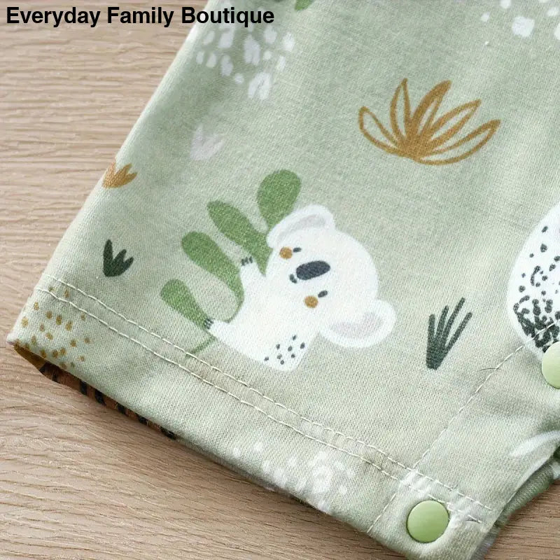 Mint green fabric with a cute koala and botanical print pattern.