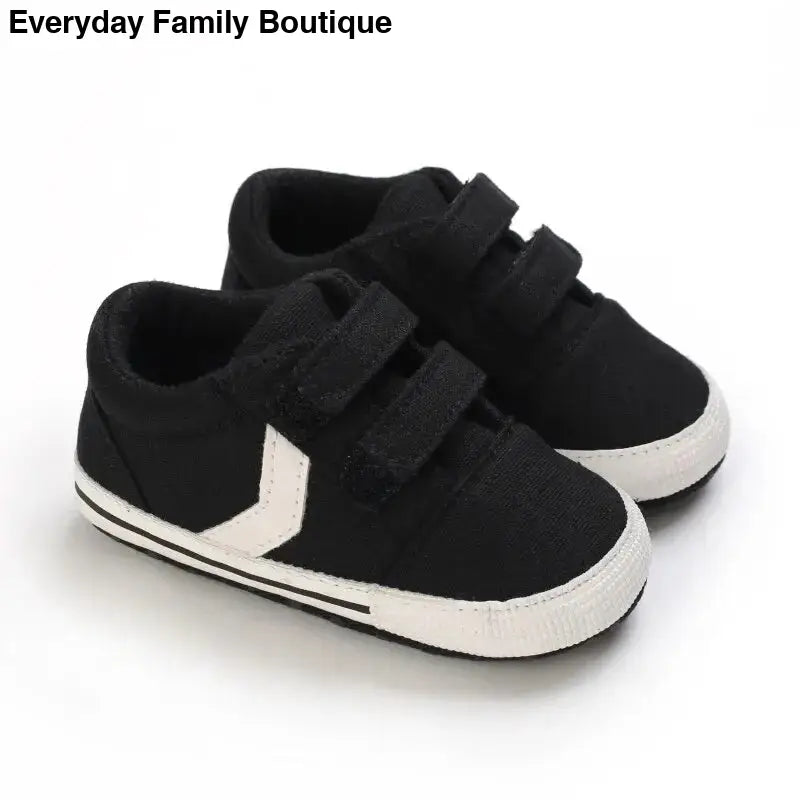 Black and white velcro sneakers with a chevron design on the side.