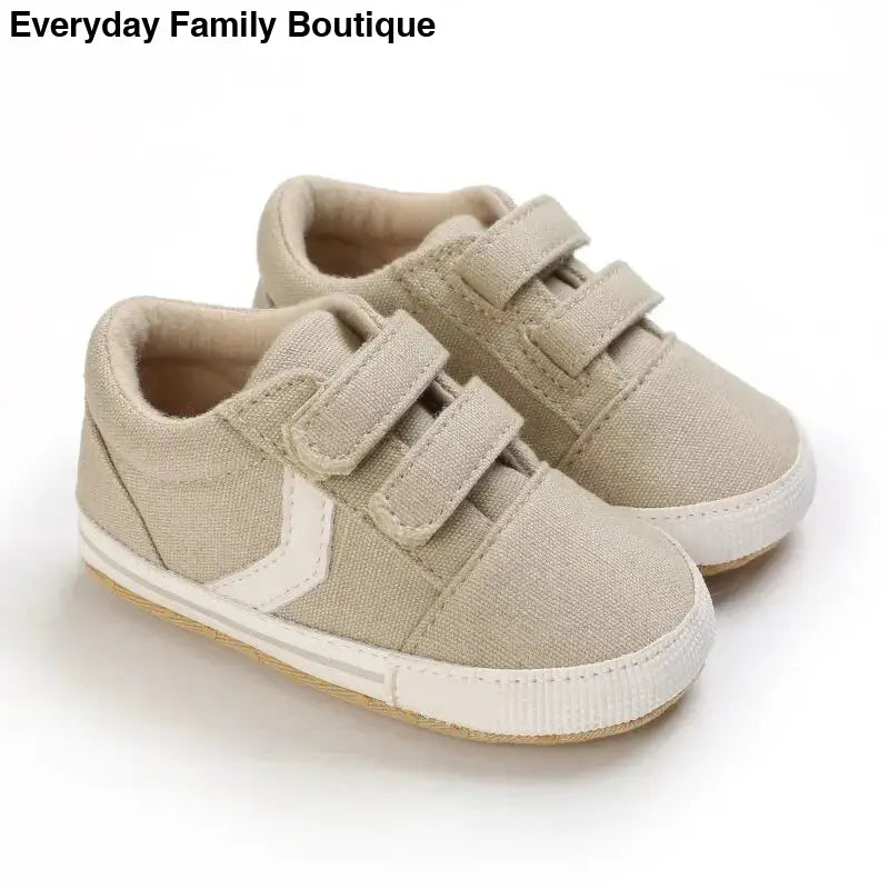 Beige canvas sneakers with velcro straps and white accents.