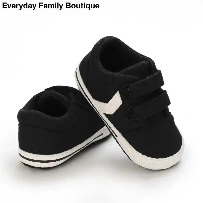 Black and white baby sneakers with velcro straps.