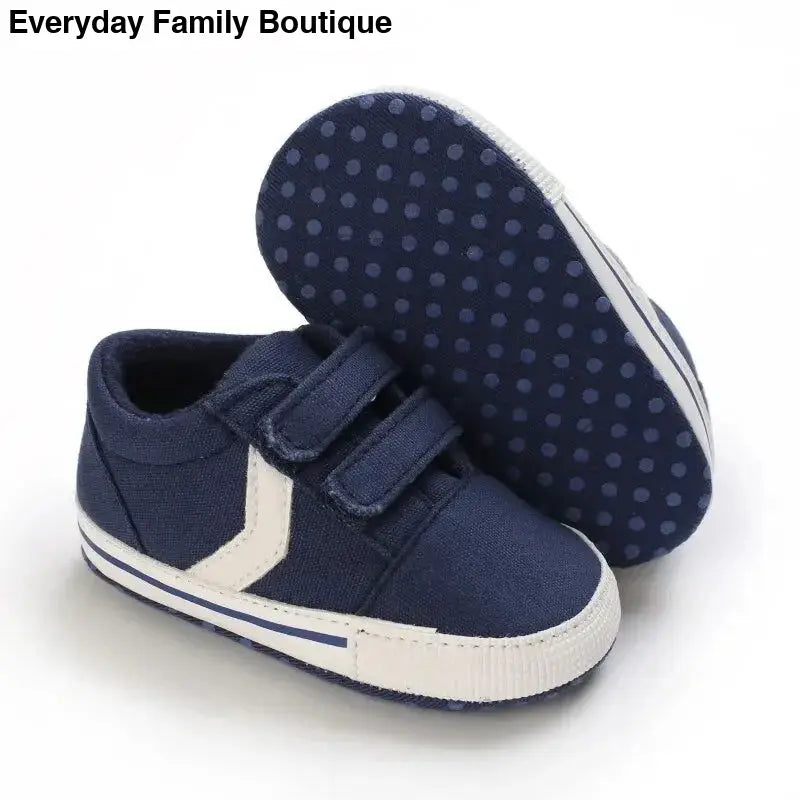 Navy blue baby sneaker with white stripes and velcro straps.