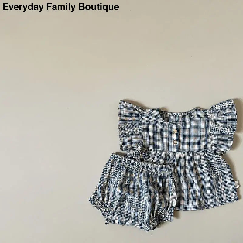 Blue and white plaid baby outfit with a ruffled top and matching bloomers.