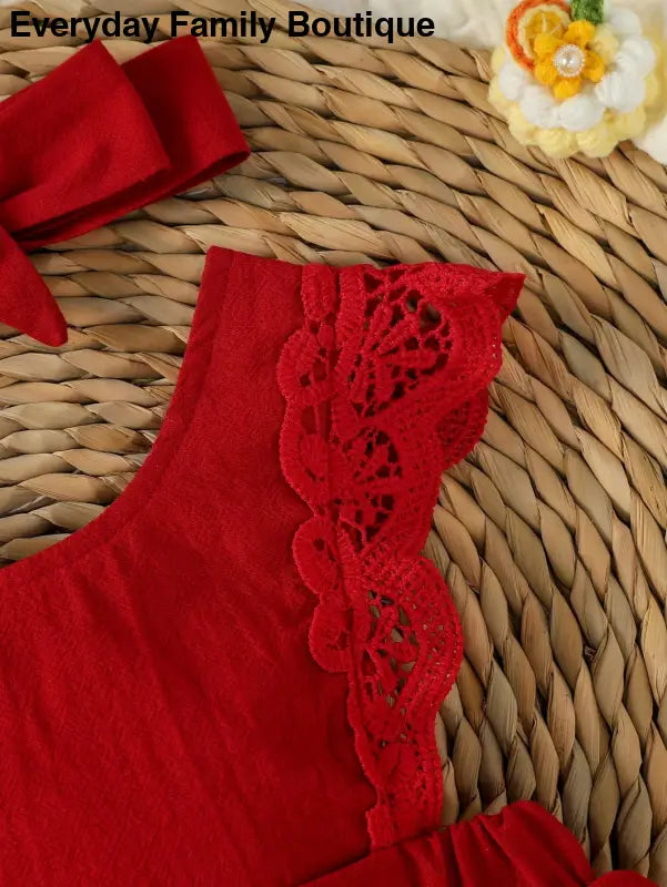 Red fabric garment with decorative lace trim along the edge.