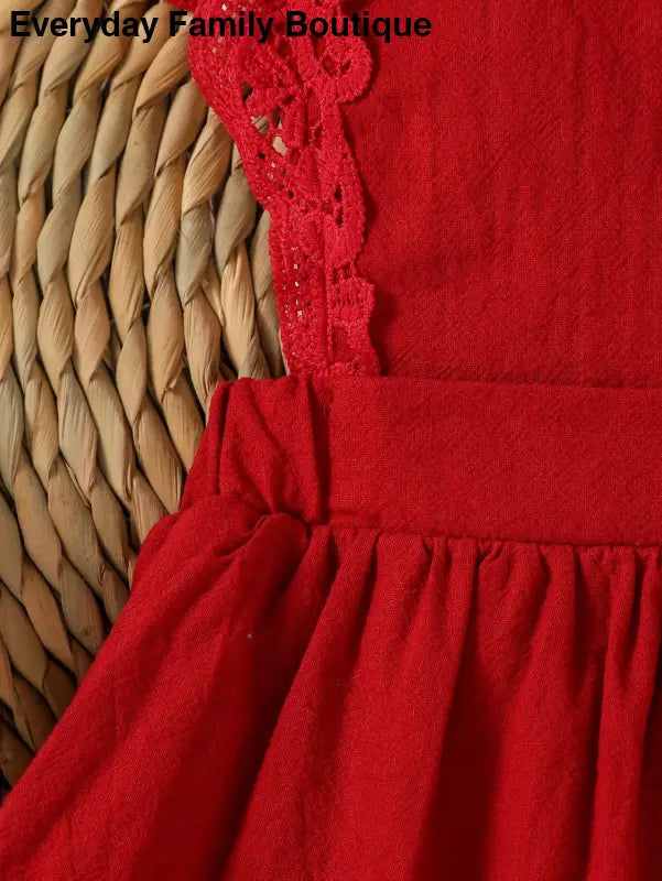 Red dress with lace trim and gathered fabric.