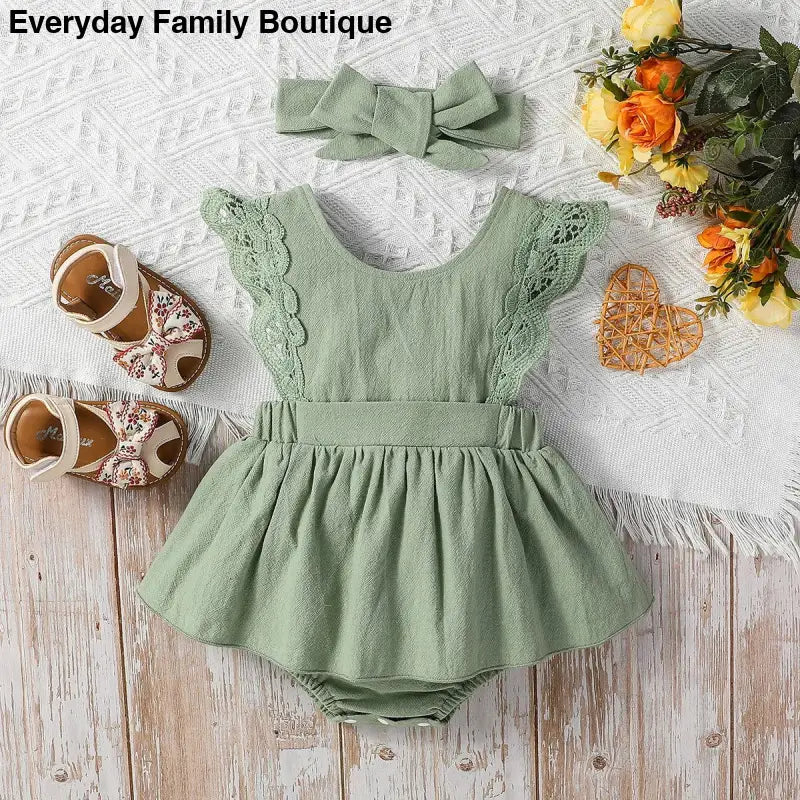 Sage green lace-trimmed baby romper dress with matching bow headband.