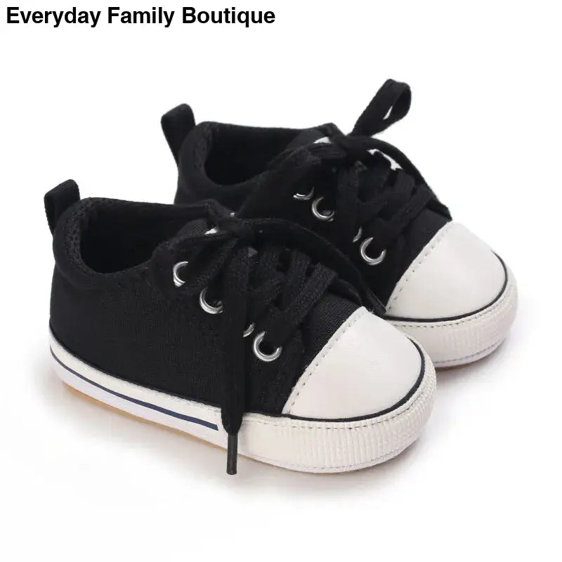 Black and white canvas baby sneakers with laces.