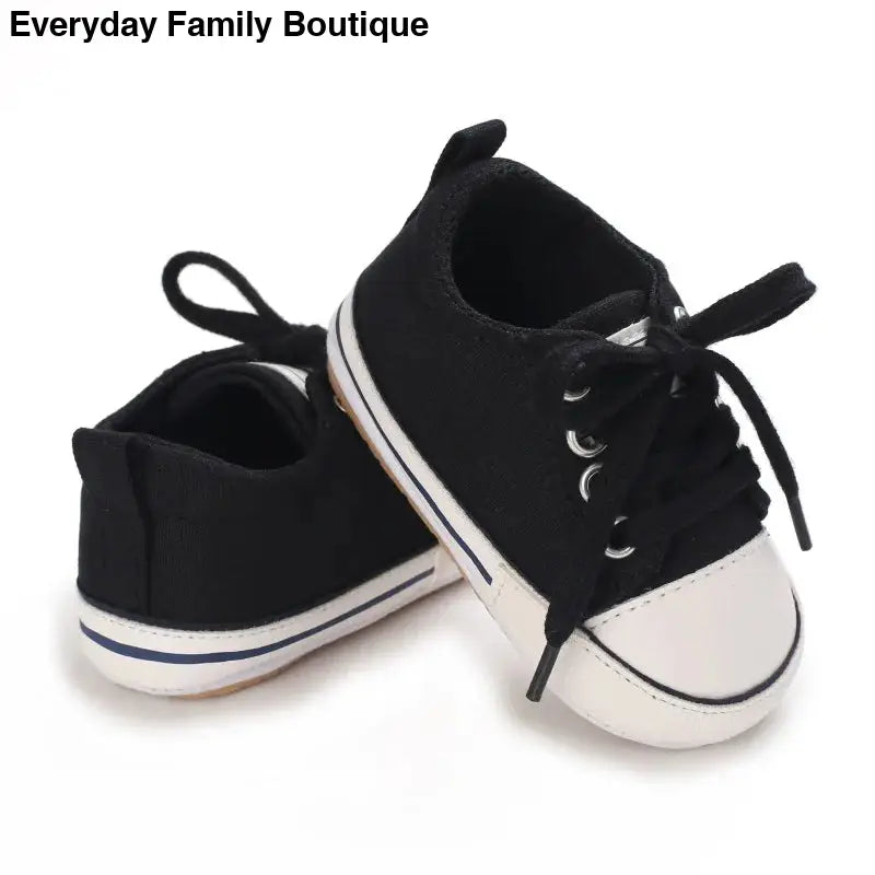 Black and white canvas baby sneakers with laces.