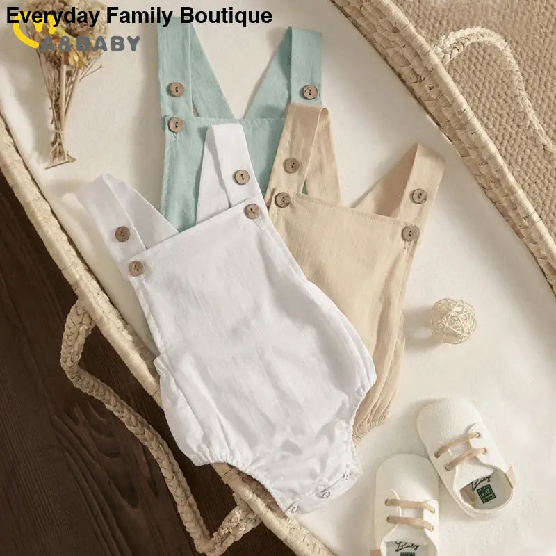 Baby romper with button straps in soft pastel colors.