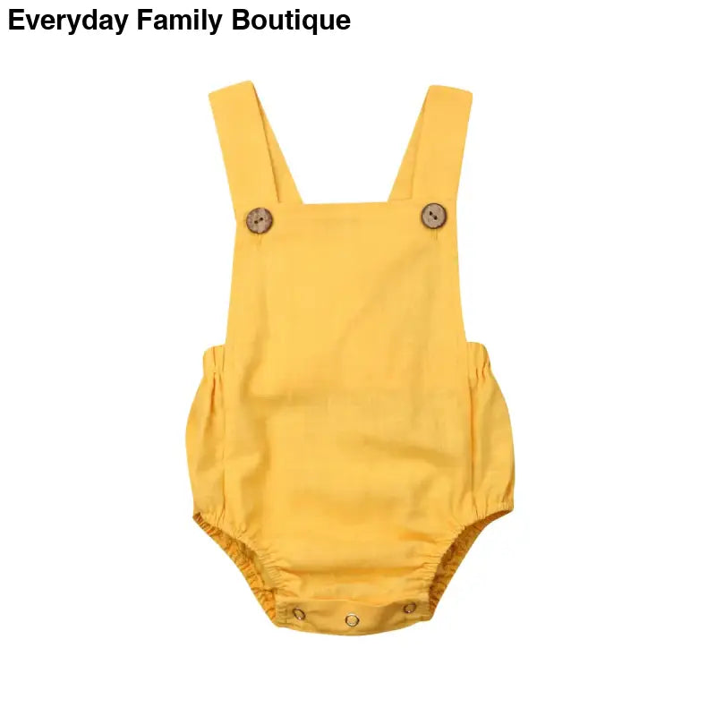 Yellow baby romper with shoulder straps and button details.