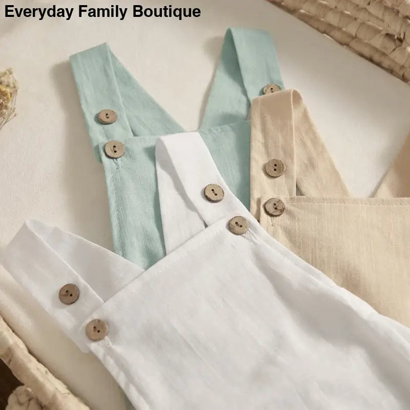 Linen overalls with button straps in white, mint green, and beige colors.