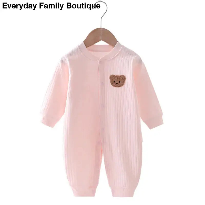 Pink baby onesie with a brown teddy bear patch.