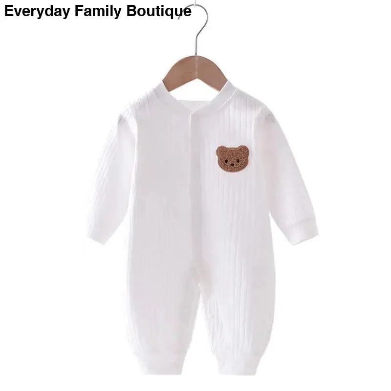 White baby romper with a brown bear patch on the chest.