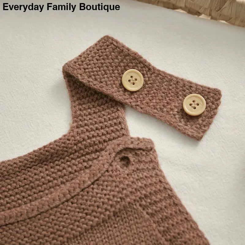 Knitted brown sweater with matching headband, both featuring wooden buttons.