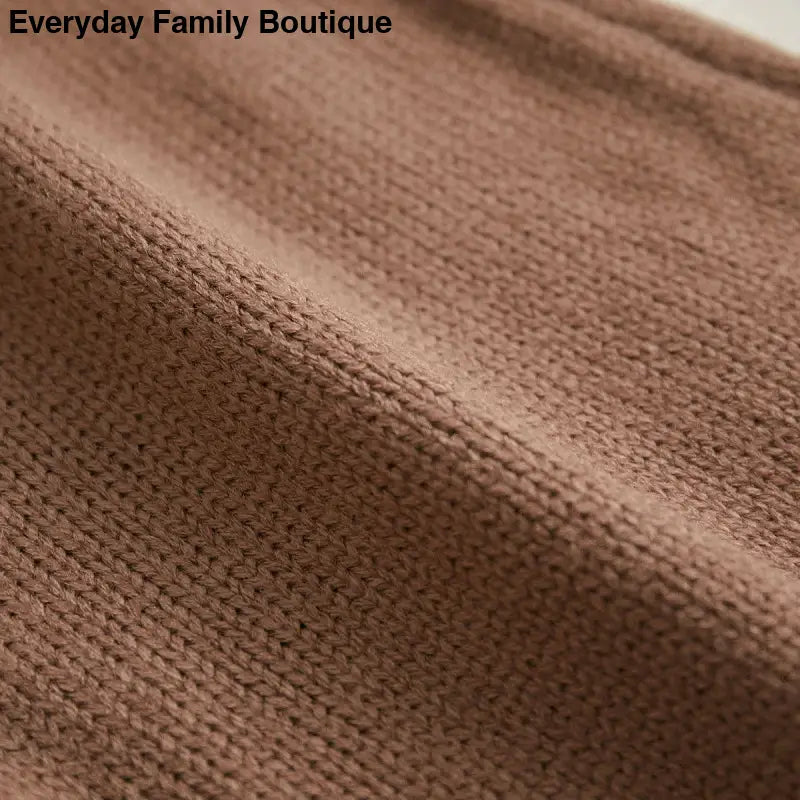 Brown knitted or woven fabric with visible textile texture.