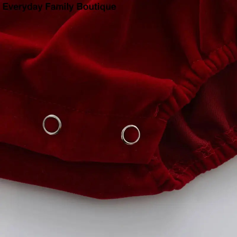 Deep red velvet fabric with metal snap fasteners.