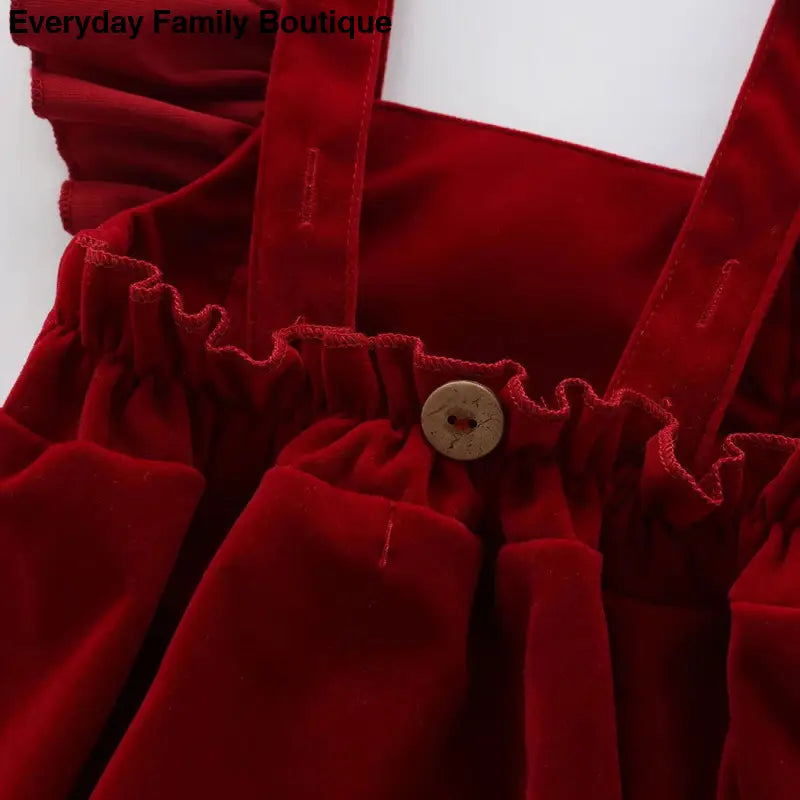 Rich red velvet fabric with gathered ruffles and a decorative button.