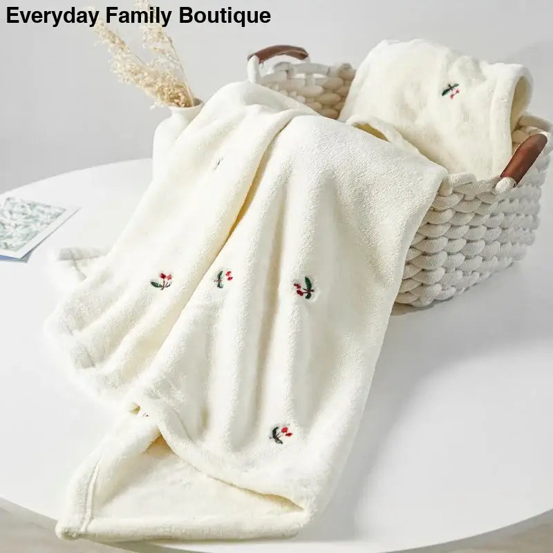 Cream-colored towel with delicate embroidered floral details.