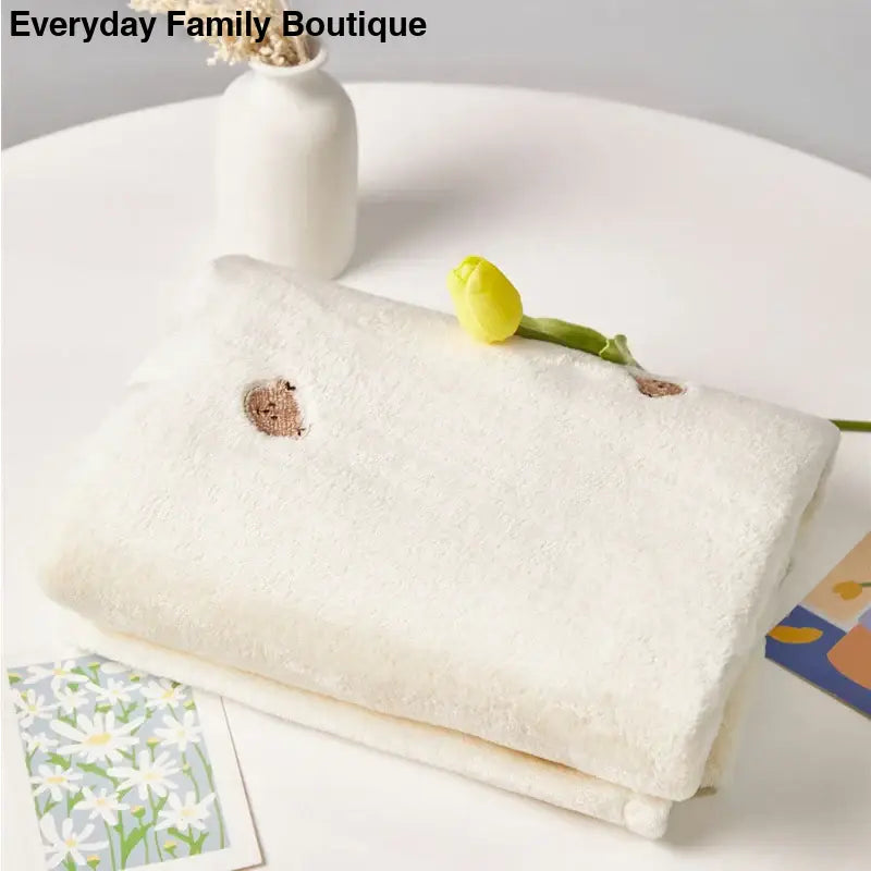 White cotton or linen towel with a small embroidered detail.