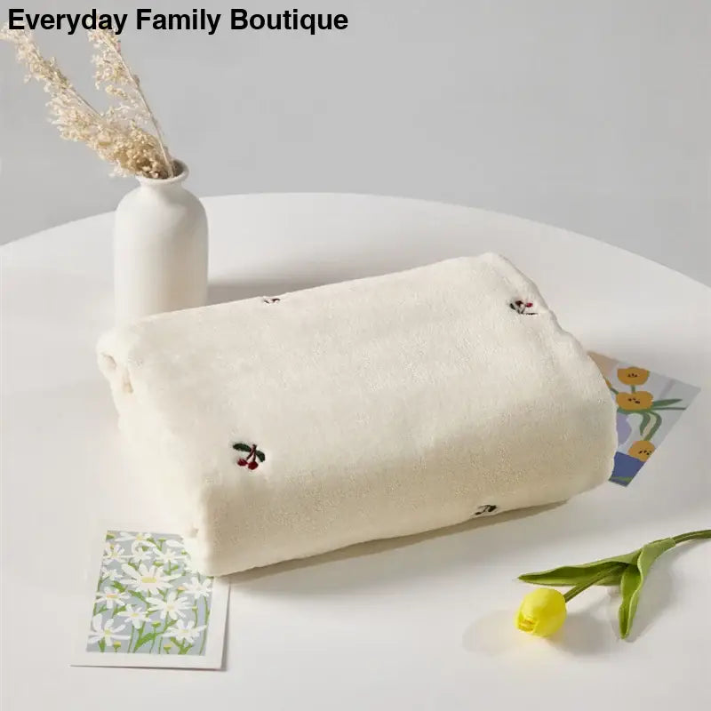 White fabric pouch with delicate bee embroidery.