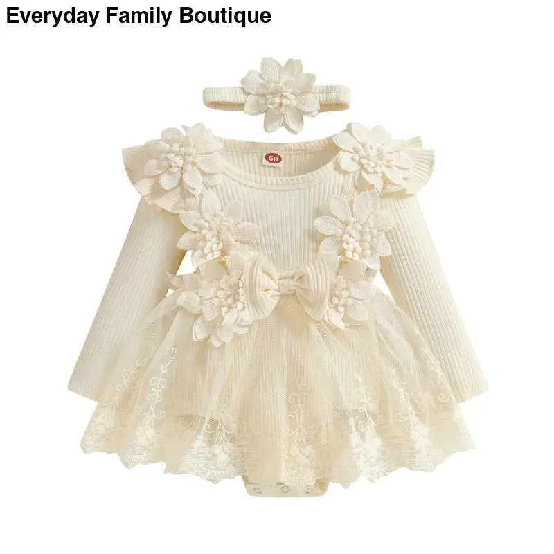 Cream-colored baby dress with floral appliques and lace details, accompanied by a matching headband.