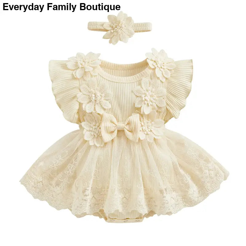 Cream-colored lace baby dress with floral appliques and matching headband.