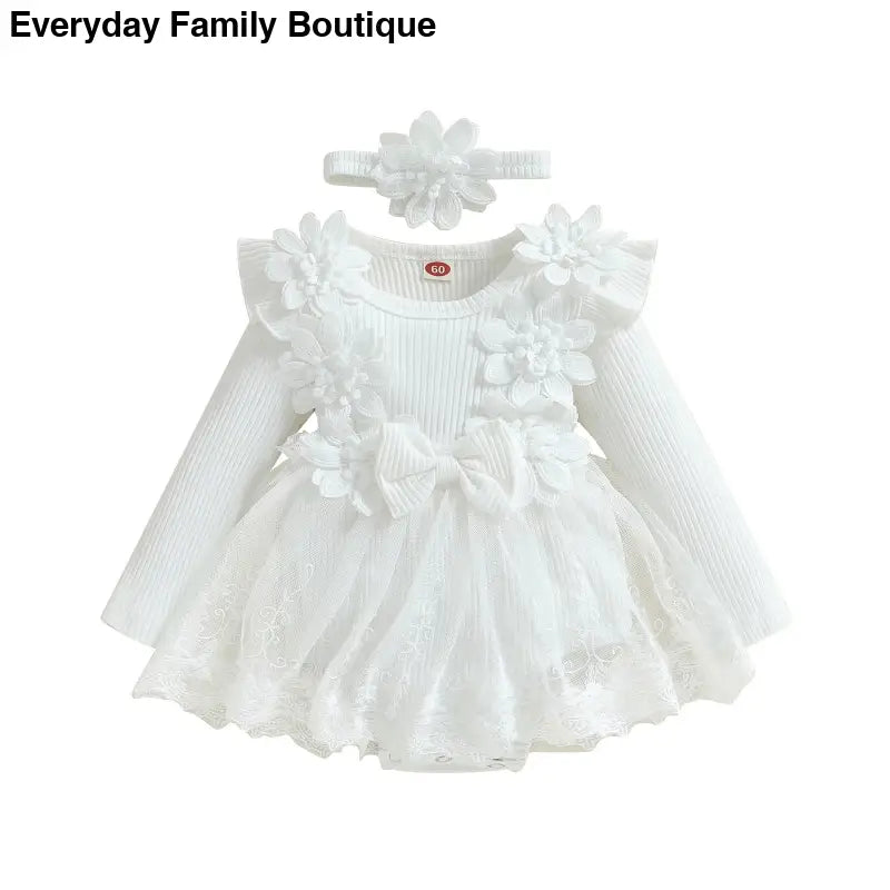 White knit baby dress with lace details, ruffles, bows, and a matching headband.