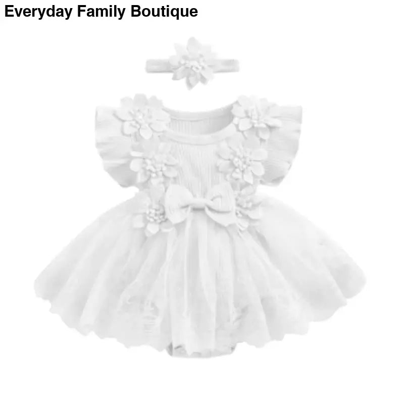 White tulle baby dress with floral appliques and matching headband.