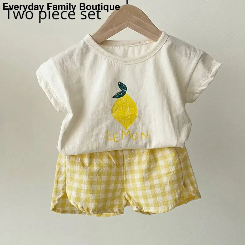 Children’s white t-shirt and yellow gingham shorts set with a lemon design.