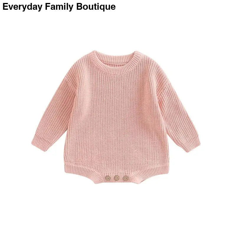 Pink knitted baby romper with long sleeves and button details at the bottom.