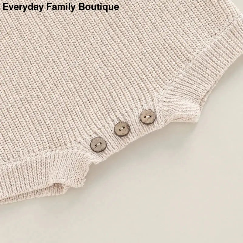 Cream-colored knit fabric with three decorative buttons along the edge.