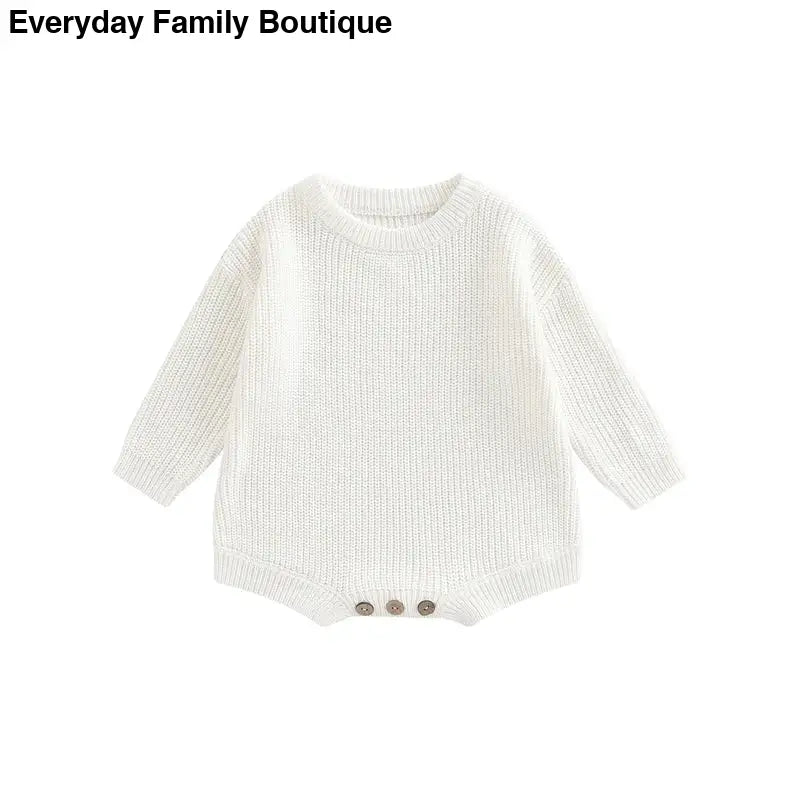 White knitted baby romper with button closures at the bottom.