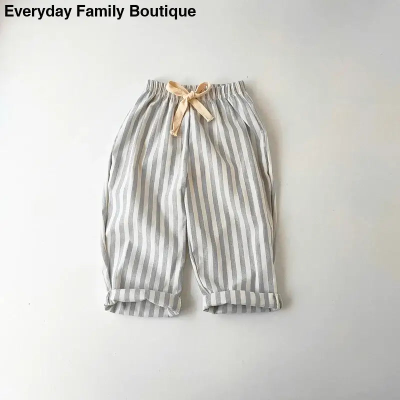 Striped gray and white cotton pants with a beige bow tie waist.