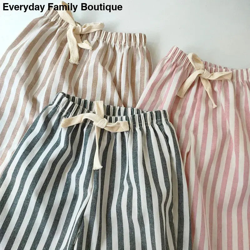 Striped linen pants with drawstring waists in beige, pink, and charcoal colors.