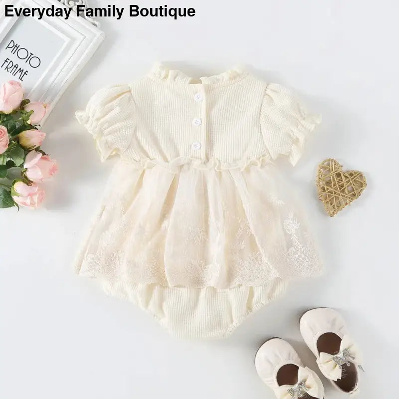 Cream-colored knit baby dress with puff sleeves and matching bloomers.