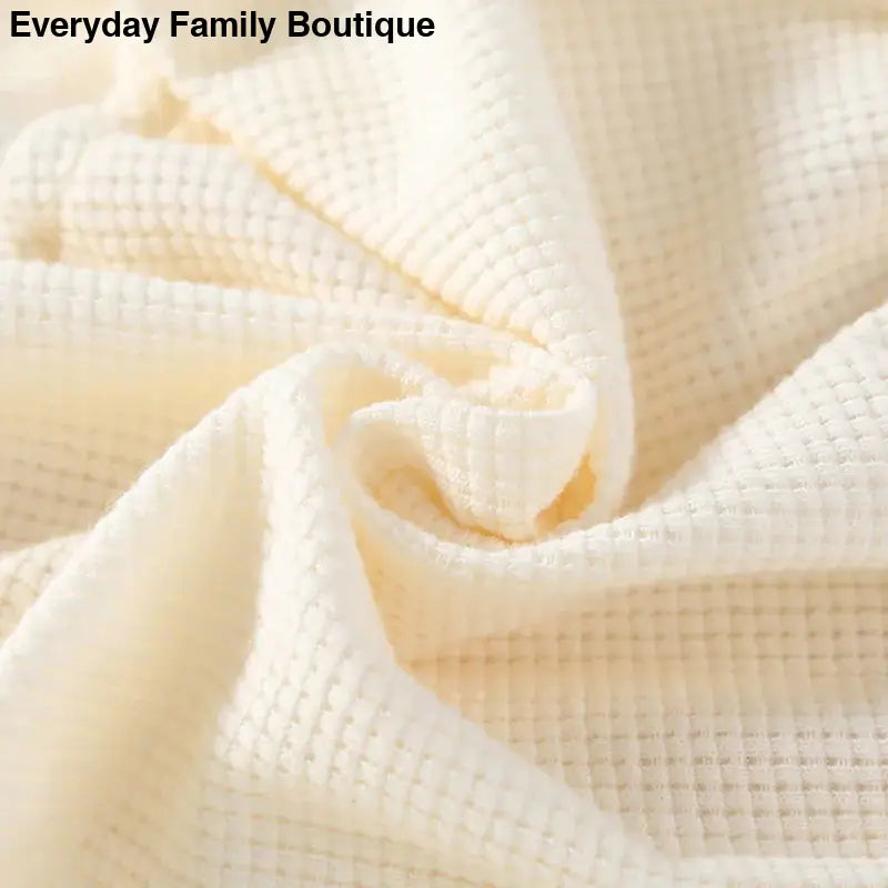 Cream-colored waffle-textured fabric twisted into a spiral fold.