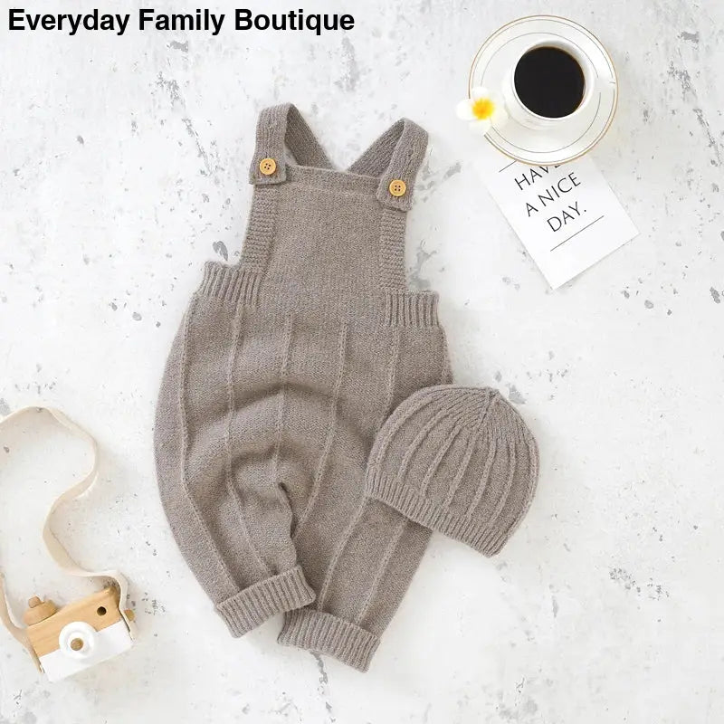 Gray knitted baby overalls with matching beanie hat.