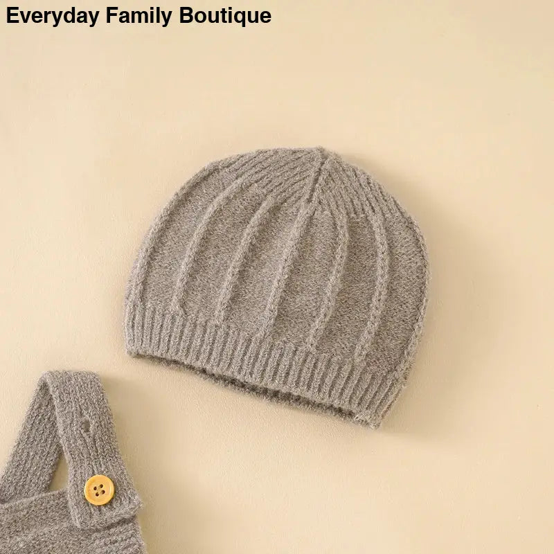 Gray knitted beanie with ribbed texture and vertical cable patterns.