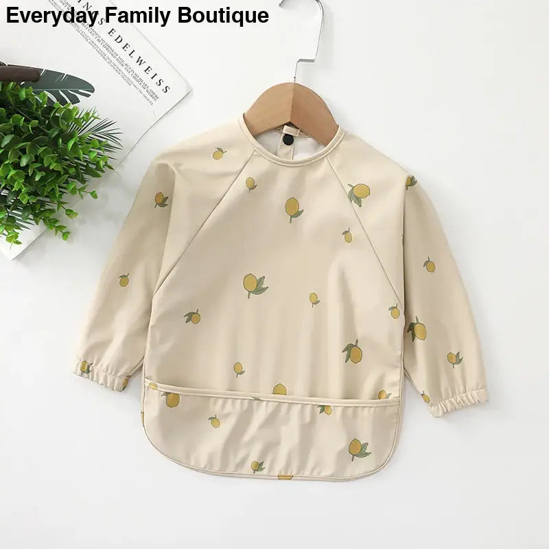 Beige long-sleeved smock with yellow lemon print pattern.