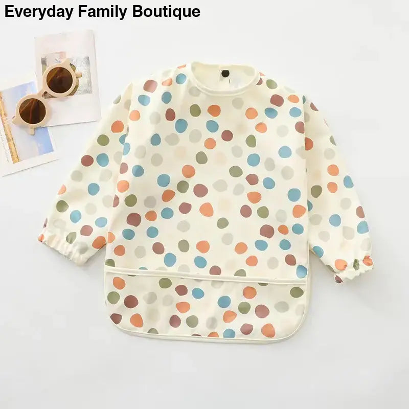 Long-sleeved polka dot bib with colorful dots on a cream background.