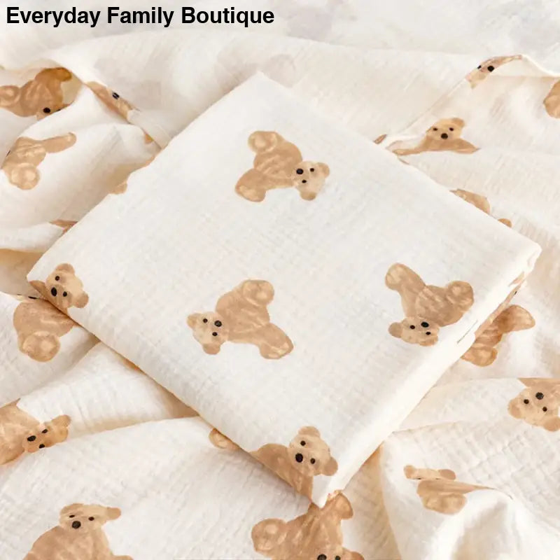 White fabric with a repeating pattern of cute brown teddy bears printed on it.