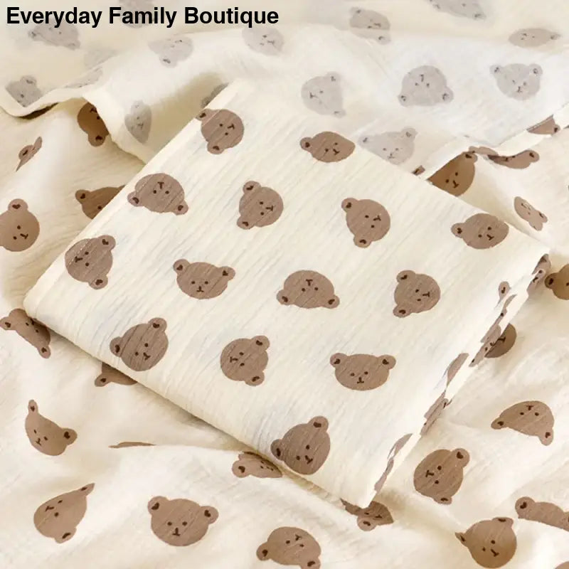 White fabric with a repeating pattern of cute brown teddy bear faces.