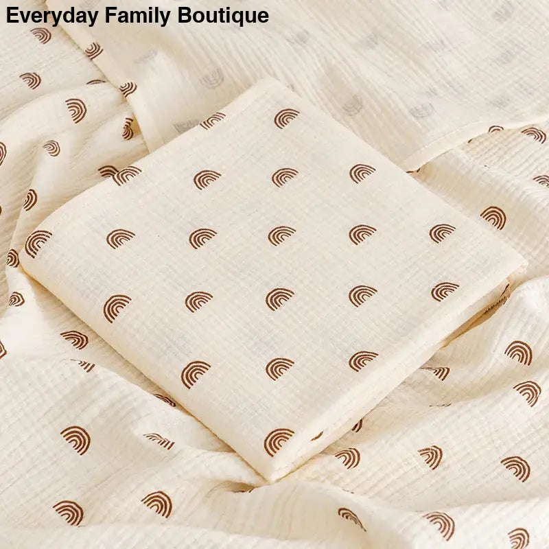 Cream-colored fabric with brown rainbow or arc pattern prints scattered across it.