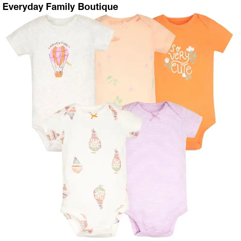 Five baby onesies in white, peach, orange, and purple colors with cute designs and text patterns.