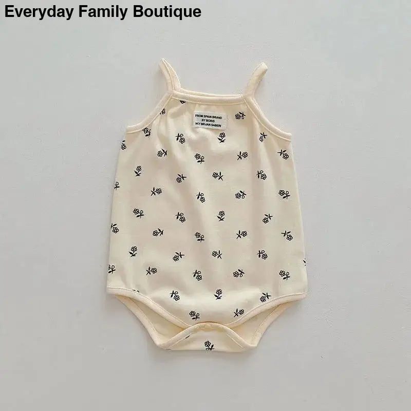 Cream-colored sleeveless baby onesie with tiny floral print pattern.