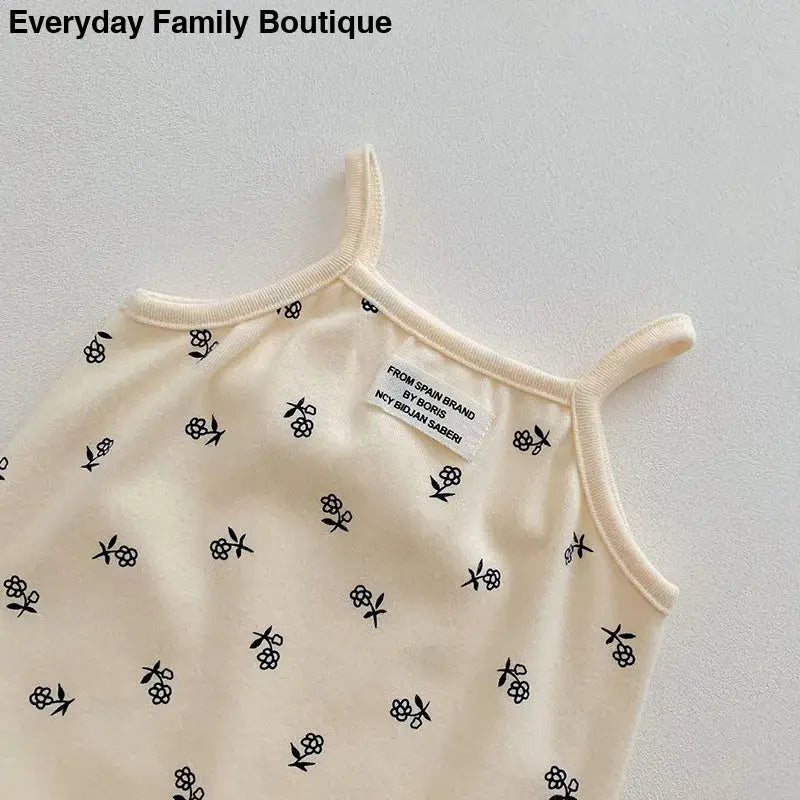 Cream-colored tank top with small black skull print pattern.