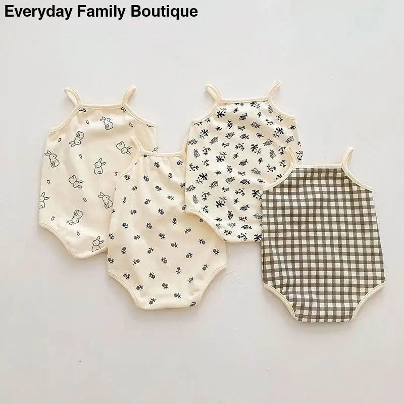 Four baby onesies in cream and brown patterns including gingham checks and small floral prints.