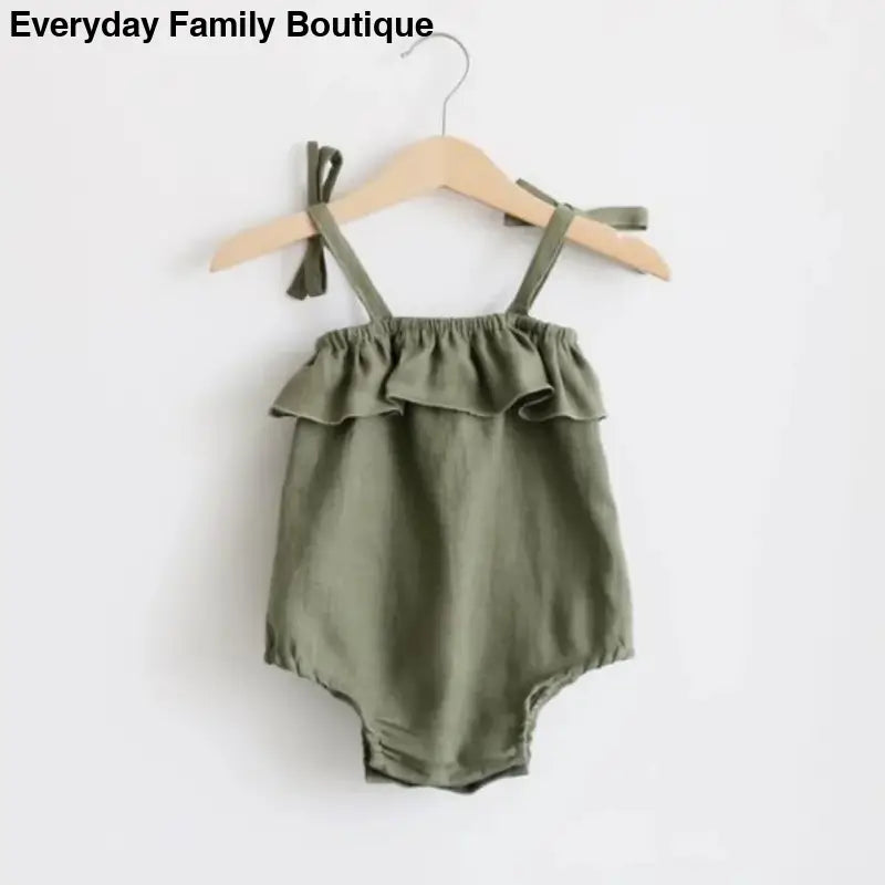 Olive green ruffled baby romper with shoulder ties hanging on a wooden hanger.