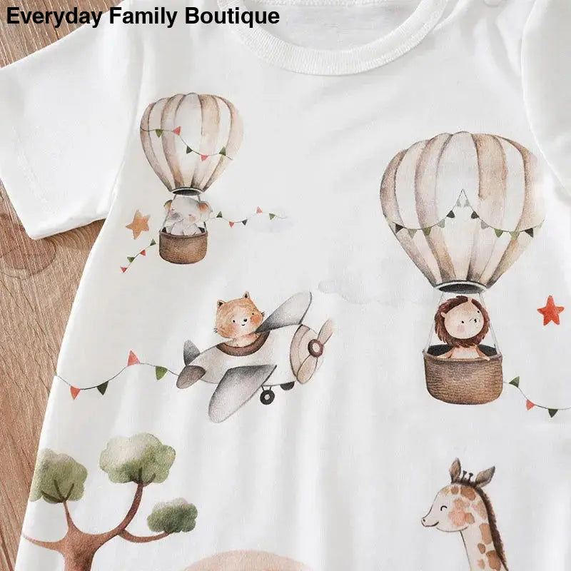 White t-shirt with whimsical hot air balloons, animals, and bunting flag illustrations.