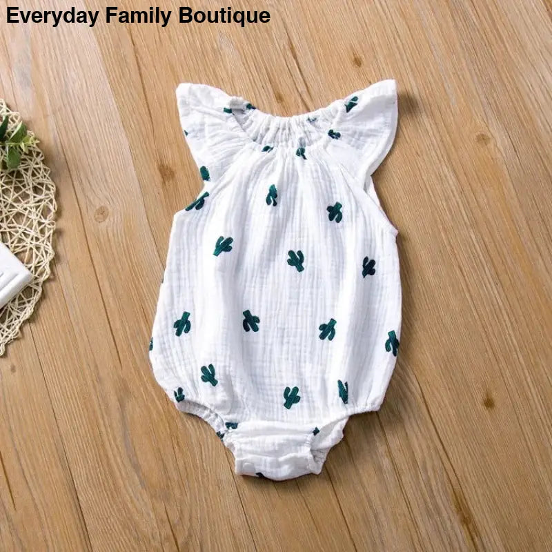 White cotton baby romper with green cactus prints and flutter sleeves.